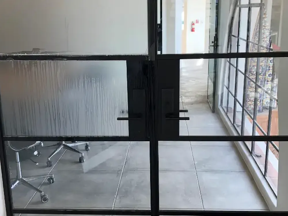 A privacy film panel going up wet on an interior glass door.