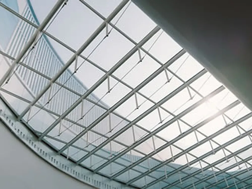 Overhead skylight glazing treated with solar film to control heat gain and glare.